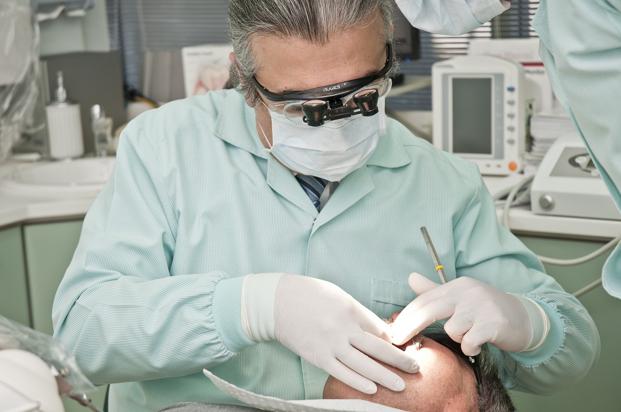 Dentista utilizando equipamento moderno durante o atendimento a um paciente em sua clínica.