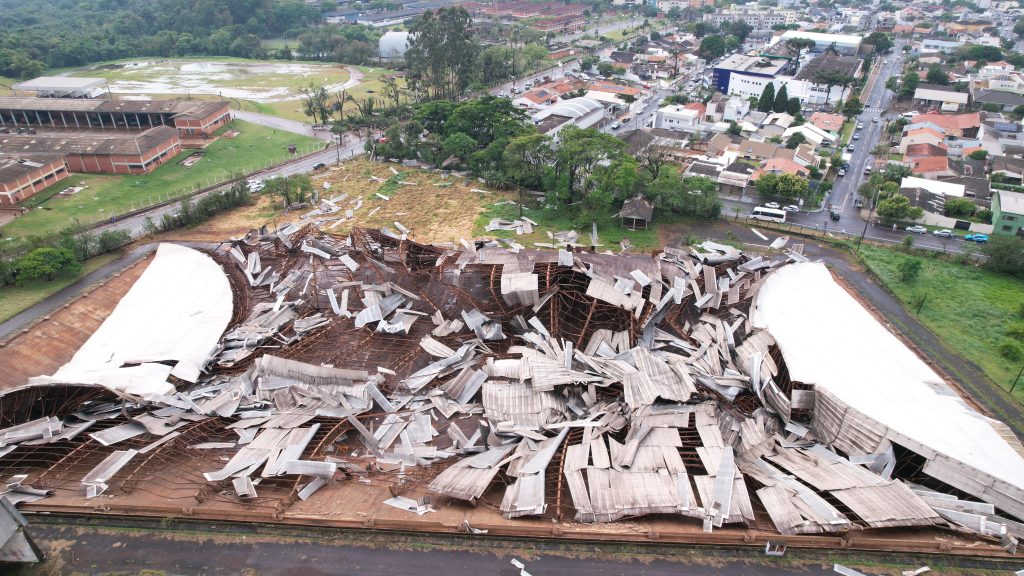 Estrutura de ginásio destruída por vendaval no Paraná, destacando os danos causados por eventos climáticos severos.